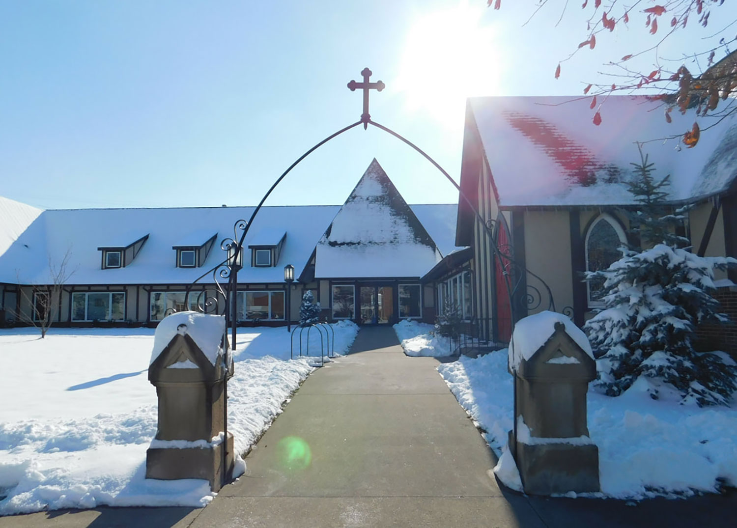 Grace Episcopal Church and Grounds covered in snow, with the sidewalk cleared out and ready for people to enter safely